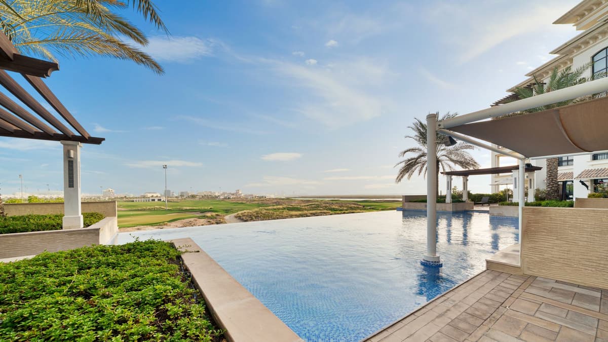 A coastal golf resort and pool under a clear southern sky